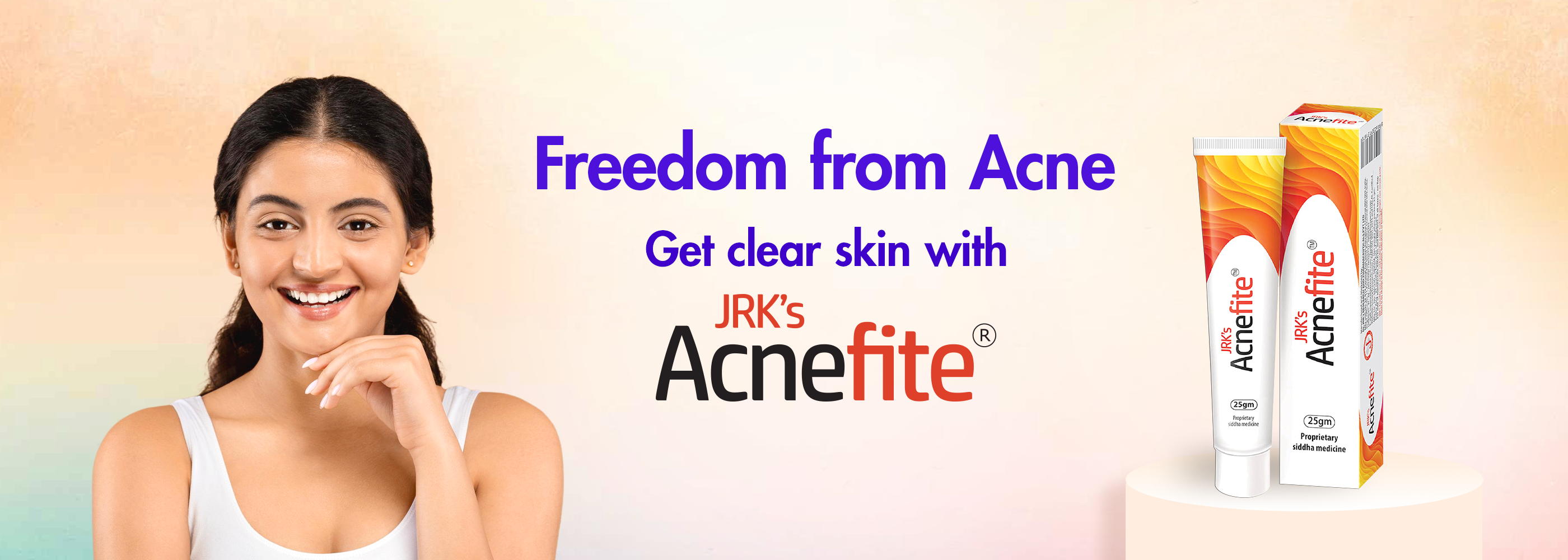 An advertisement banner for JRK's Acnefite cream, featuring a smiling woman on the left and two tubes and boxes of the cream on a pedestal on the right, set against a pastel gradient background with text reading 'Freedom from Acne Get clear skin with JRK's Acnefite'.